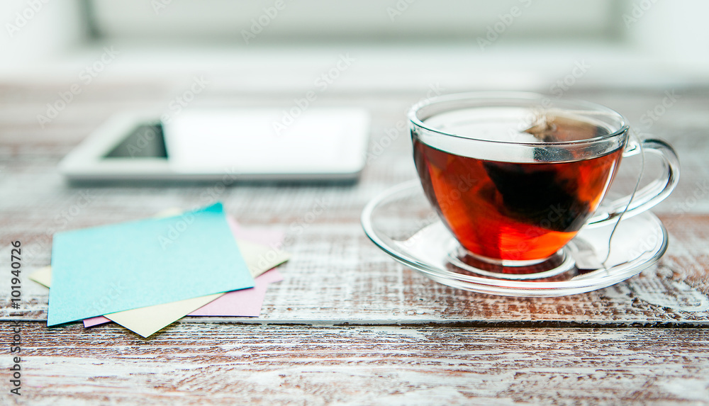 Fototapeta premium red tea with a tablet on a table in an office