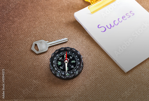 compass with text success in business concept and key background photo