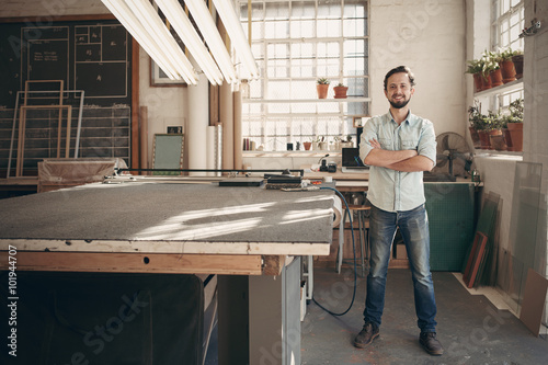 Confident designer standing in his workshop studio