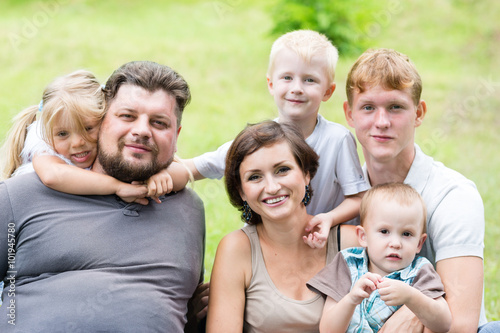 Portrait of happy family sitting on the grass