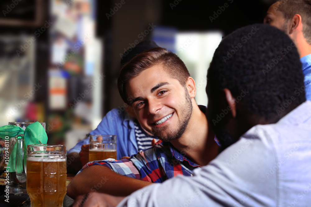 Young men drinking beer in pub Young men drinking beer in pub
