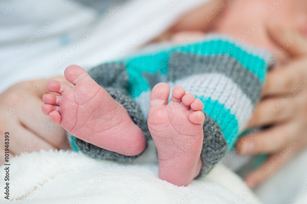Infant's small feet closeup with mother hands Infant's small feet closeup with mother hands