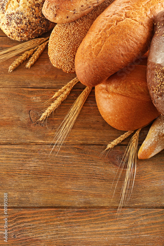 Assortment of fresh baked bread on the wooden background