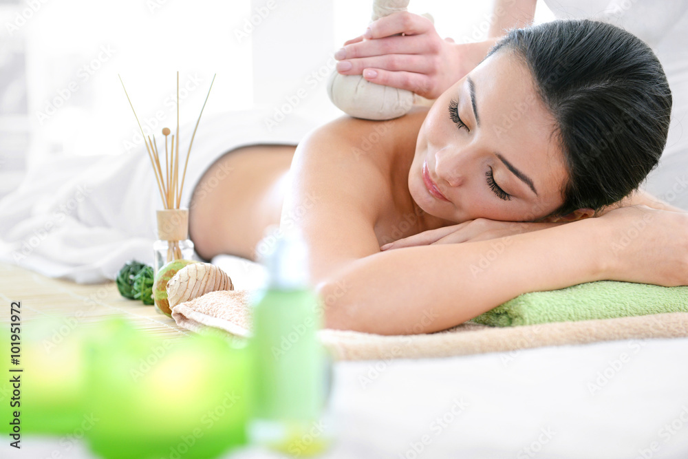 Spa concept. Someone do relaxing massage with herbal balls to beautiful woman, close up Spa concept. Someone do relaxing massage with herbal balls to beautiful woman, close up