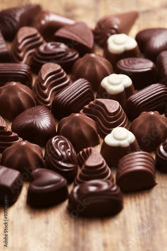 Delicious chocolate candies on wooden background