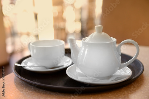 Tray with cup and teapot on table close up