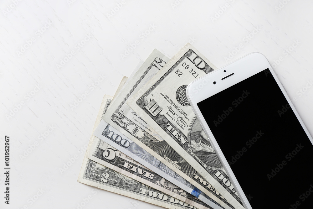 Smart phone on dollar banknotes over light table. Internet earning concept Smart phone on dollar banknotes over light table. Internet earning concept