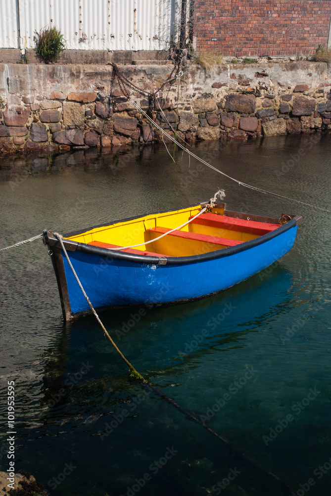 Blue and yellow rowing boat in a harbour