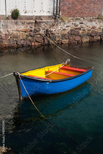Blue and yellow rowing boat in a harbour
