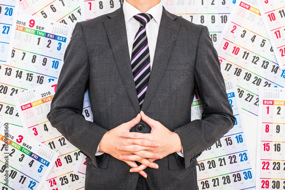 Fotografie カレンダーの前で悩むビジネスマン