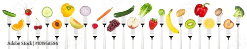 row of tasty fruits and vegetables on forks isolated on white background