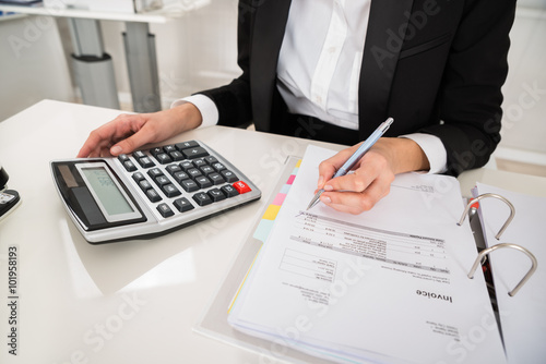 Businesswoman Doing Financial Calculation At Desk