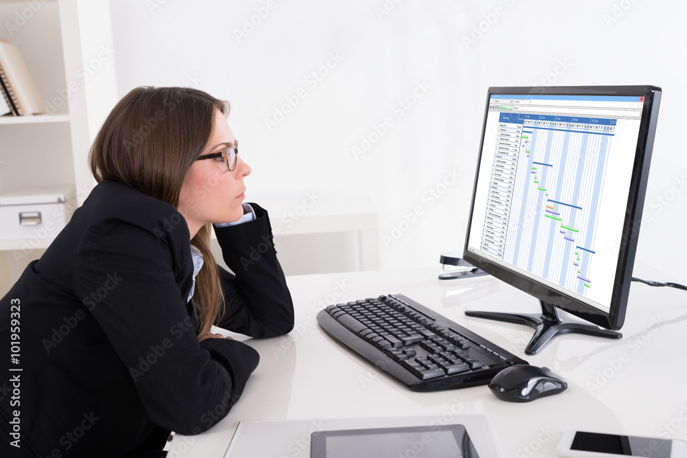 Businesswoman Looking At Gantt Chart On Computer Businesswoman Looking At Gantt Chart On Computer