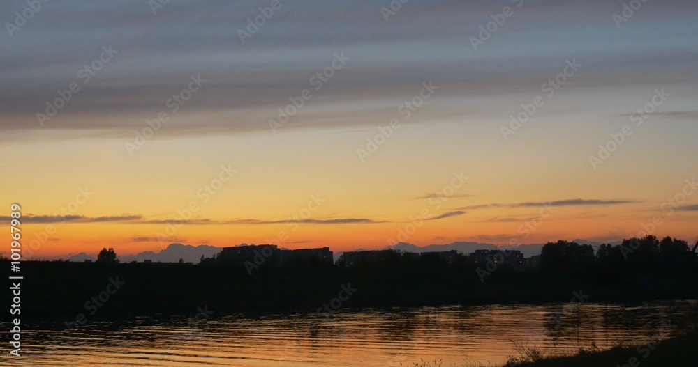 River Bank Buildings at Opposite Bank Buildings on a Horizon Yellow Sky Twilights Sunset Rippling Water of the Pond Trees Silhouettes Reflection River Bank Buildings at Opposite Bank Buildings on a Horizon Yellow Sky Twilights Sunset Rippling Water of the Pond Trees Silhouettes Reflection