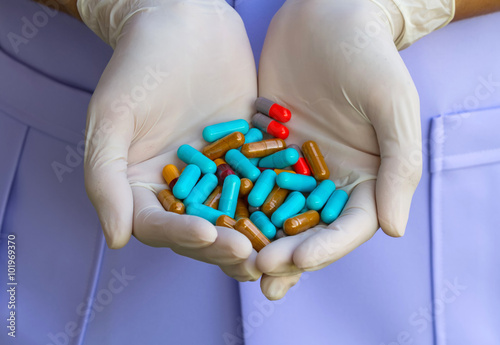 colorful pills  on disposable glove  in hand of doctor