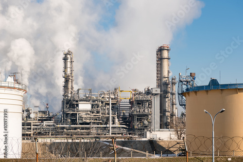 oil refinery with smoking chimneys against blue sky