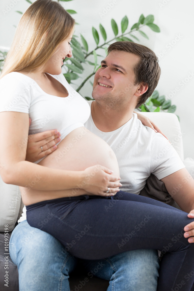happy man hugging and looking at pregnant wife happy man hugging and looking at pregnant wife