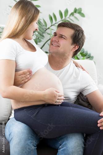 happy man hugging and looking at pregnant wife
