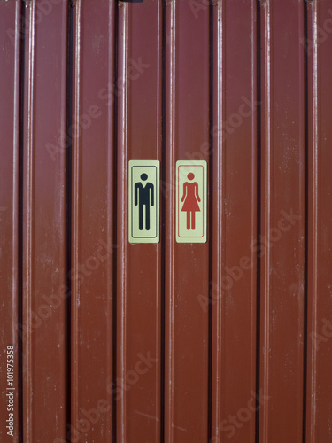 man woman yellow wc signal on red pattern metal wall photo