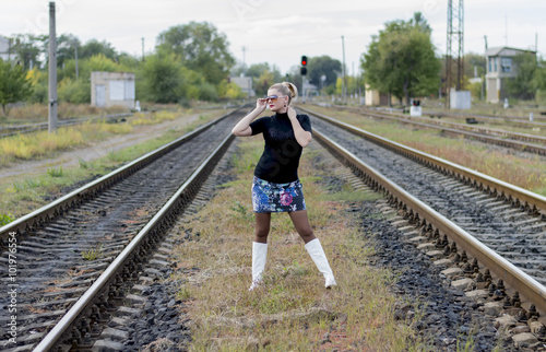 the beautiful woman in sunglasses between two railway tracks