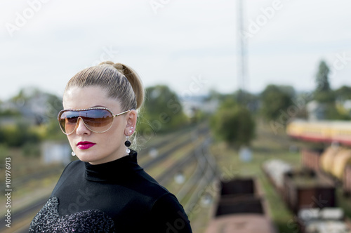 portrait of the beautiful woman against the train and railway tr
