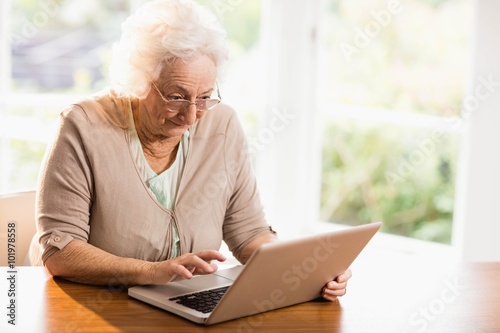 Focused senior woman using laptop