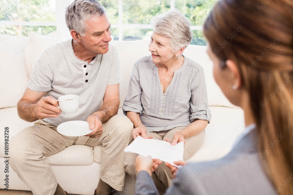 Businesswoman showing documents to senior couple Businesswoman showing documents to senior couple