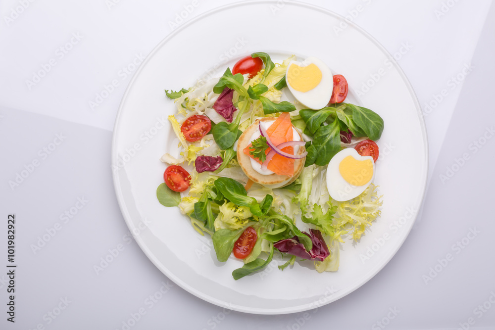 green salad with eggs in the shape of a heart, salmon, cherry tomatoes green salad with eggs in the shape of a heart, salmon, cherry tomatoes