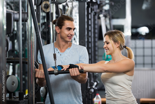 Adults having strength training under coach control in gym