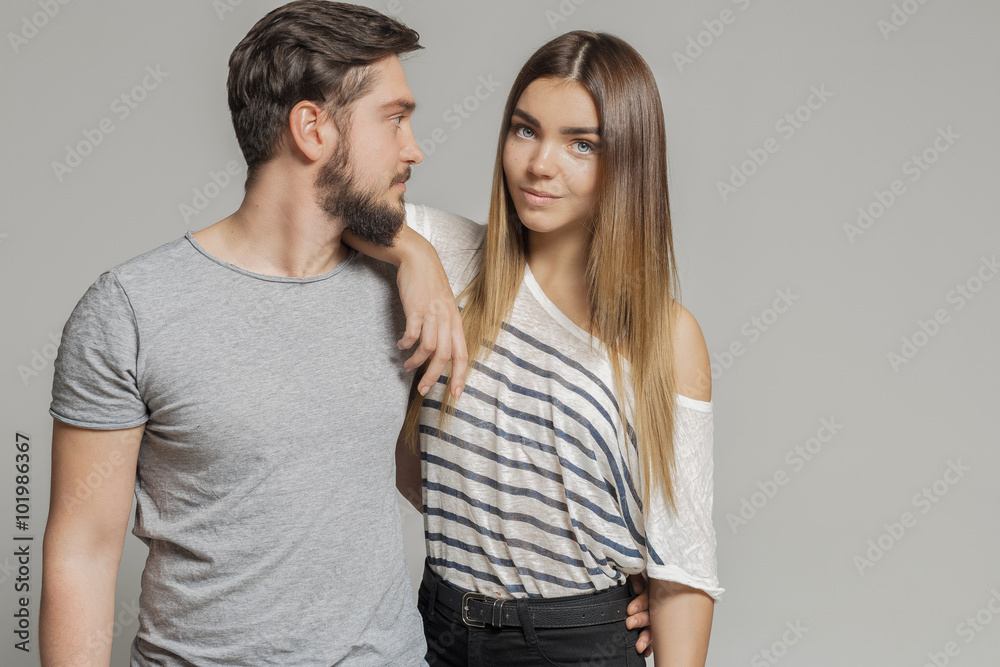 Casual loving couple on grey background Casual loving couple on grey background