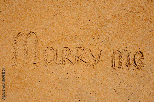 Marry Me Word Written On Sunny Beach Sand