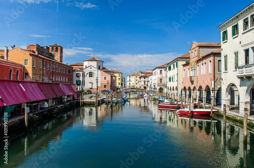 View over channel witn boats, houses and reflections in Chioggia