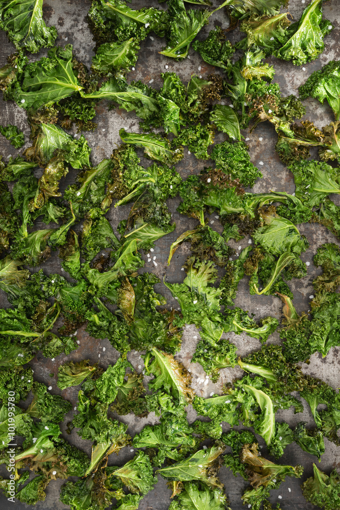 Kale chips with sea salt on a an rustic baking tray