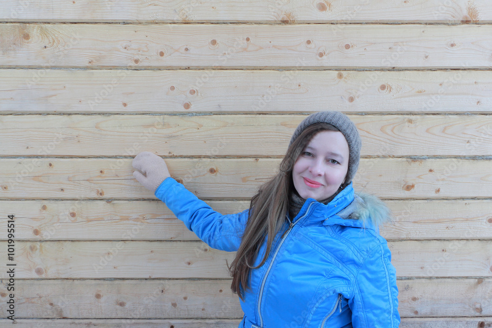 The woman with long hair in a blue jacket standing at a wall of the house under construction from a bar
The woman with long hair in a blue jacket standing at a wall of the house under construction from a bar