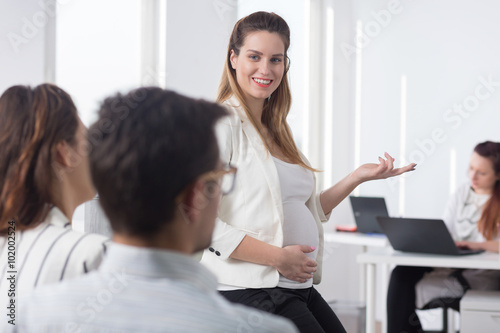 Pregnant woman during business meeting