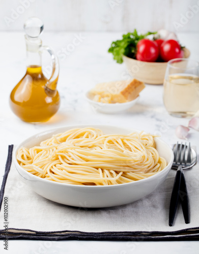 Cooked spaghetti pasta in plate on grey napkin Pasta ingredients on grey stone background