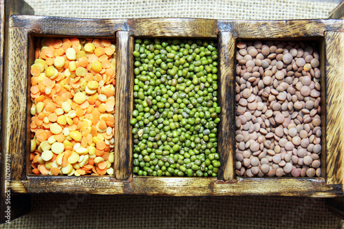 Different kinds of lentils in a wooden box.