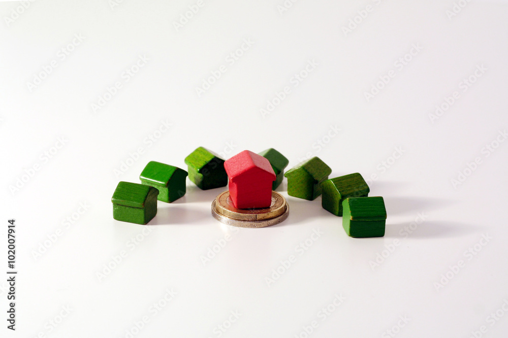Crisi finanziaria e mercato immobiliare: monete in euro e piccole casette di legno Crisi finanziaria e mercato immobiliare: monete in euro e piccole casette di legno