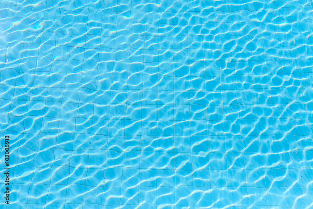 Blue swimming pool rippled water detail in the shining day 