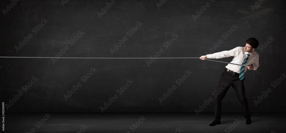 Businessman pulling rope on grey background Businessman pulling rope on grey background