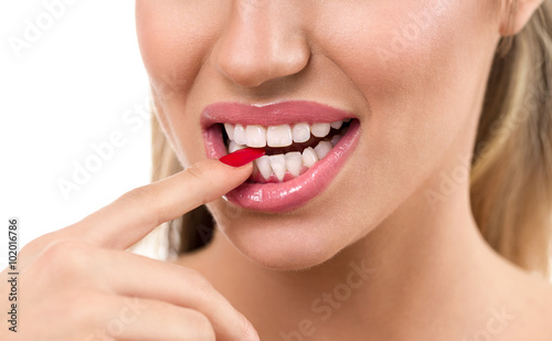 Sexy woman mouth with finger between tooth