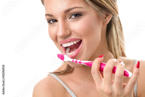 Woman holding toothbrush and  brushing teeth