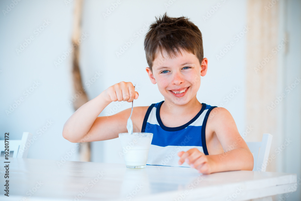 Smiling little boy eating delicious yogurt Smiling little boy eating delicious yogurt
