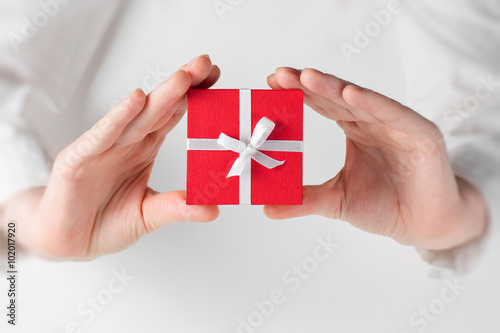 Hand holding box for a gift on white