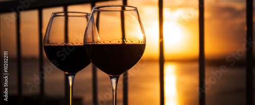 Two glasses with red wine in sunset
