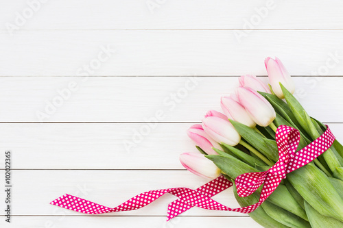 Fototapeta Naklejka Na Ścianę i Meble -  Bouquet of pink tulips on white wooden background. Top view