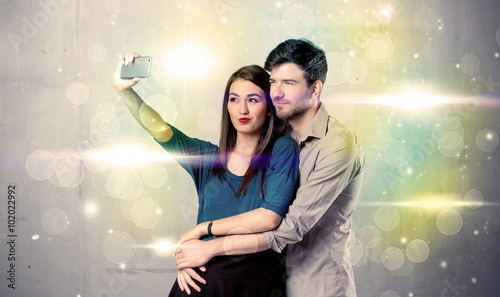 Smiling couple taking selfie in glitter light