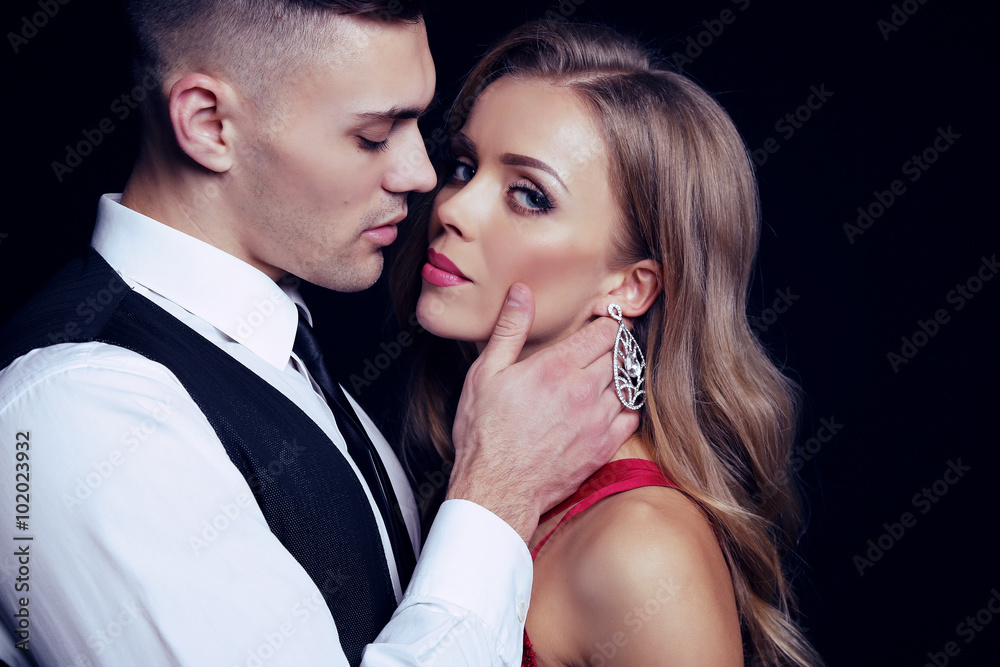 fashion studio photo of impassioned beautiful couple. sexy woman with blond hair and handsome brunette man fashion studio photo of impassioned beautiful couple. sexy woman with blond hair and handsome brunette man