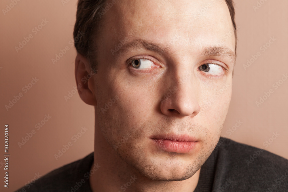 Obraz premium Young serious Caucasian man looking left, close-up