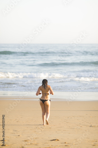 Mujer en bikini caminando por una playa del Algarve